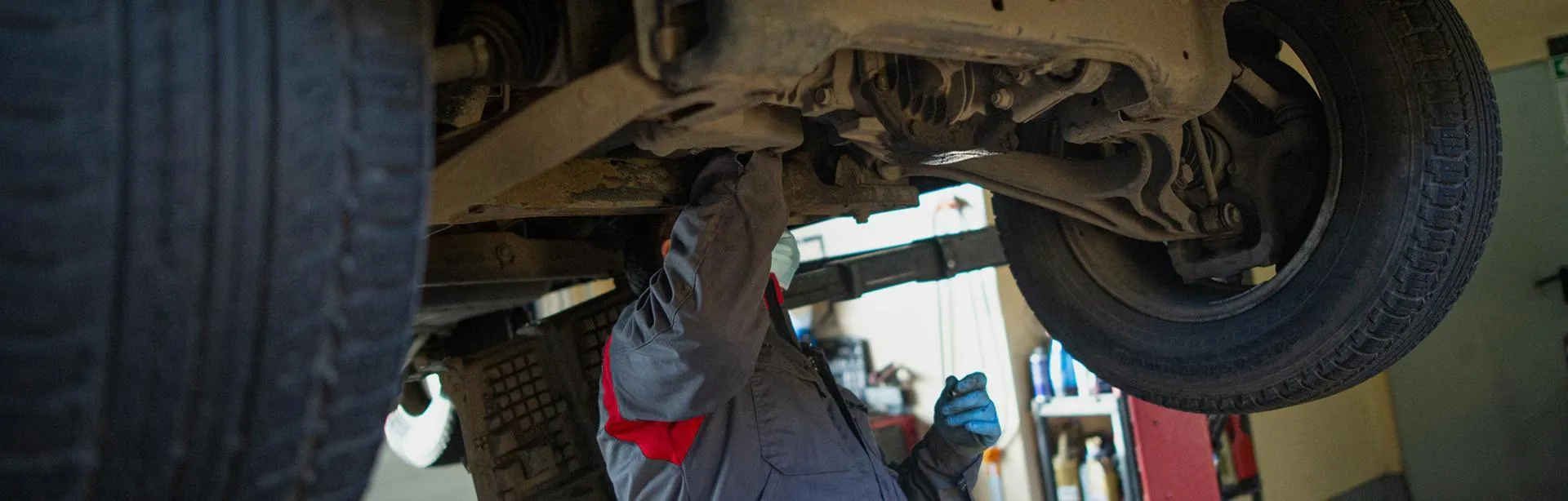 Slajd #3 - mechanik przeglądający podwozie samochodu